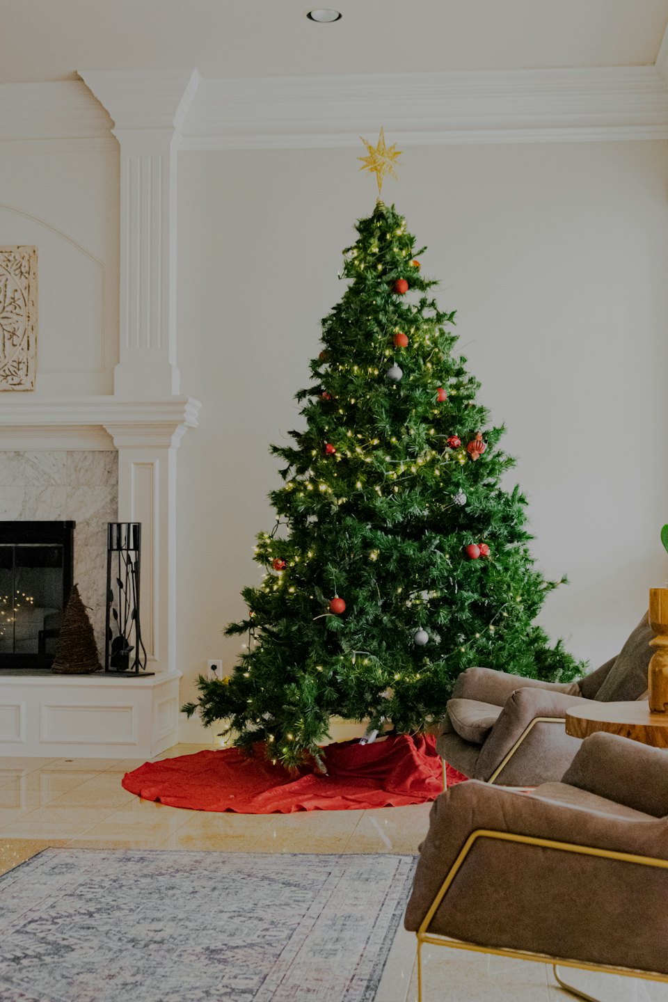 Decorated Christmas tree on a red skirt in a modern living room.